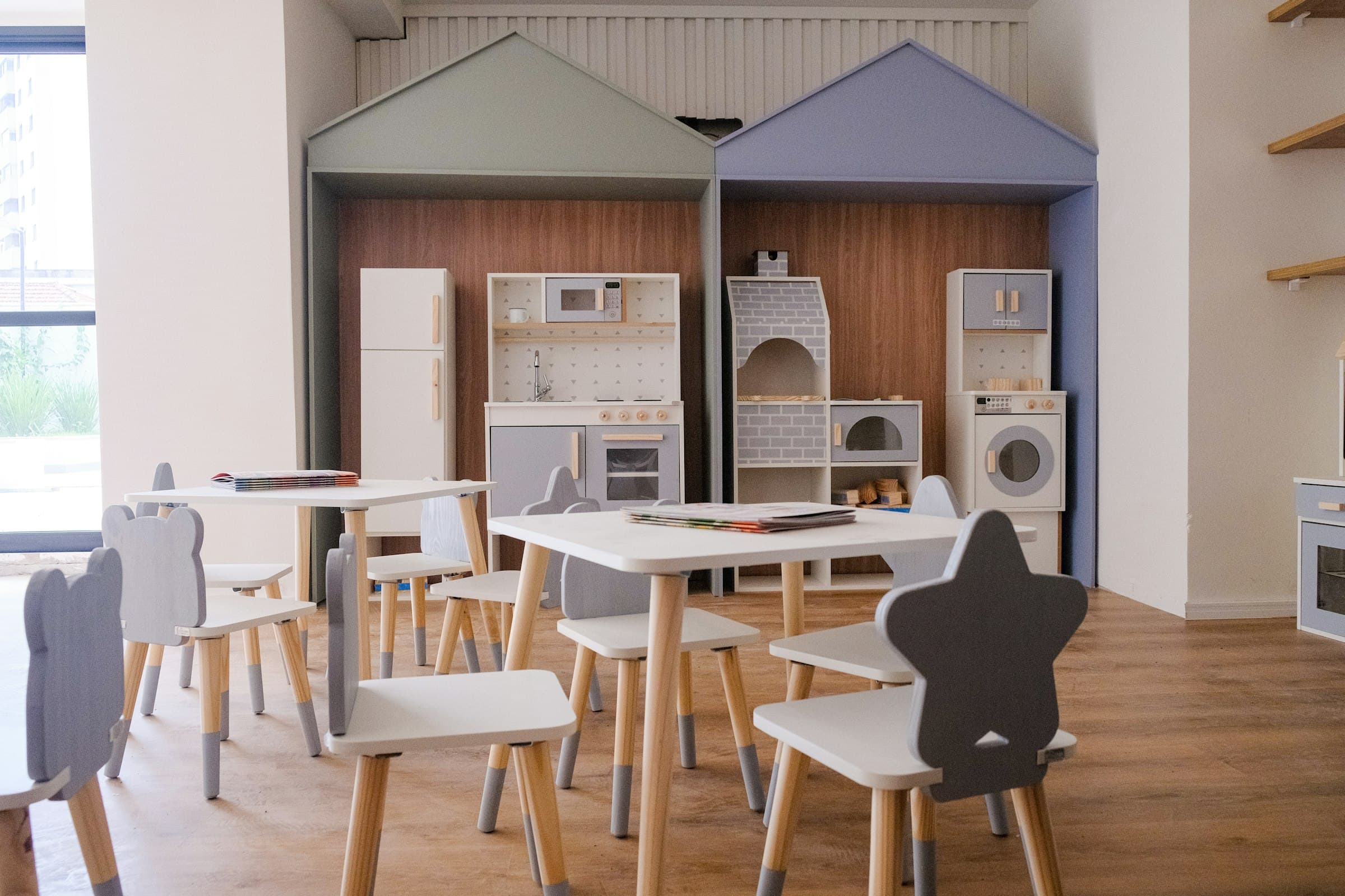 A play kitchen and child-sized tables in a bright playroom